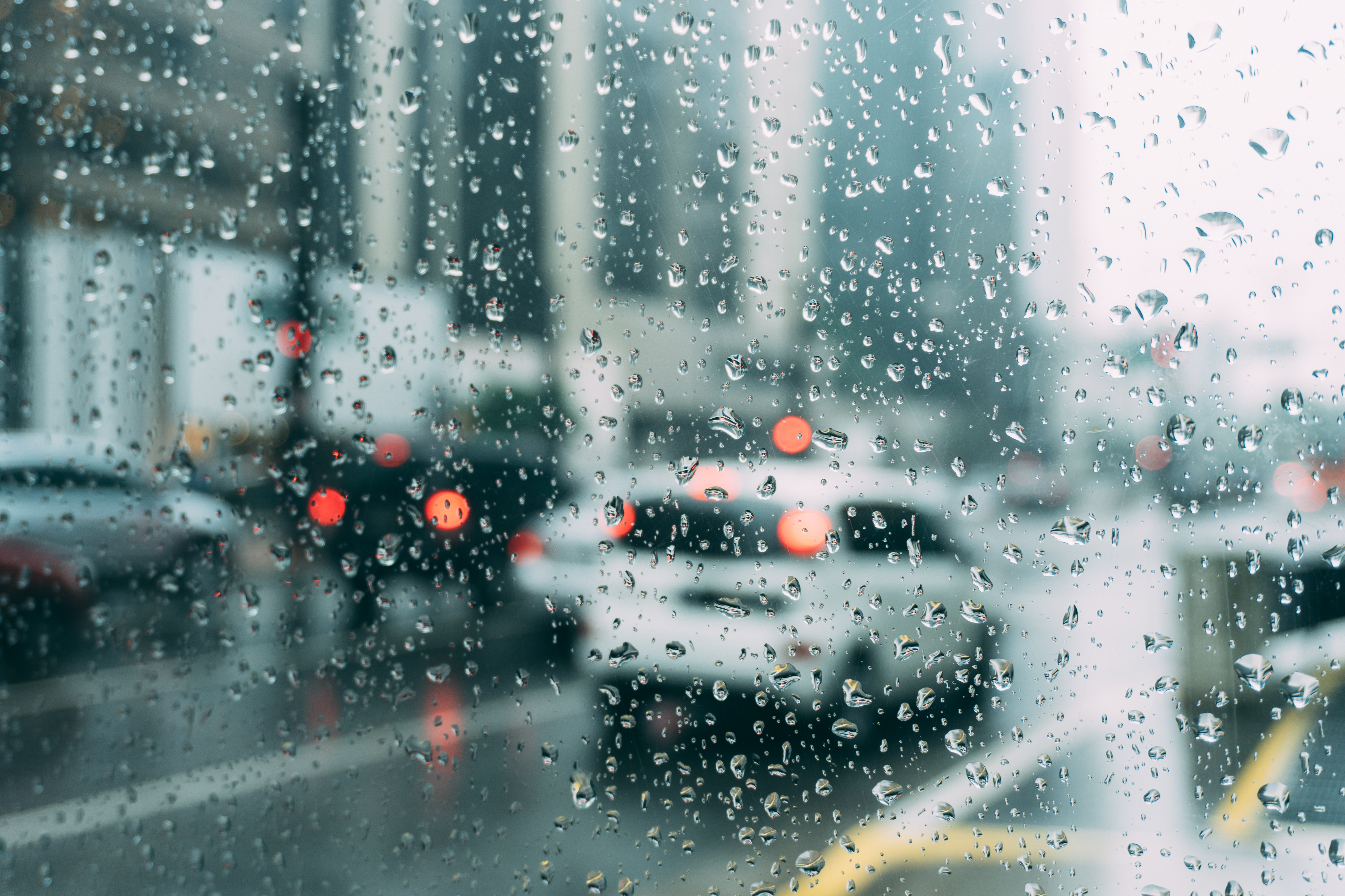 A glass blurred with raindrops on a road