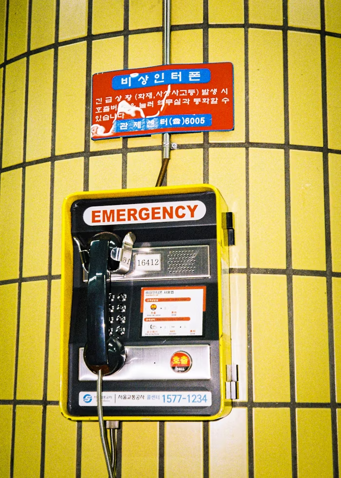 A photo of an emergency landline with a yellow background.