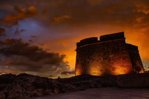 A photo of a stone fortress amid the sunset.