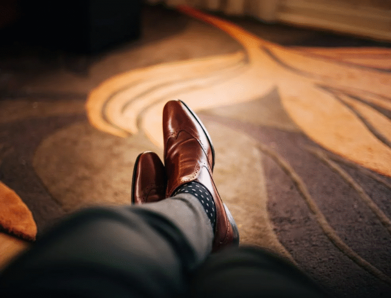 Legs with luxury shoes on the feet on a warm-toned carpet