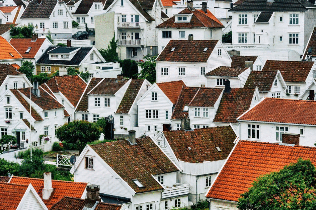 A whole neighborhood of white houses with brown roofs clustered together