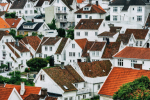 A whole neighborhood of white houses with brown roofs clustered together