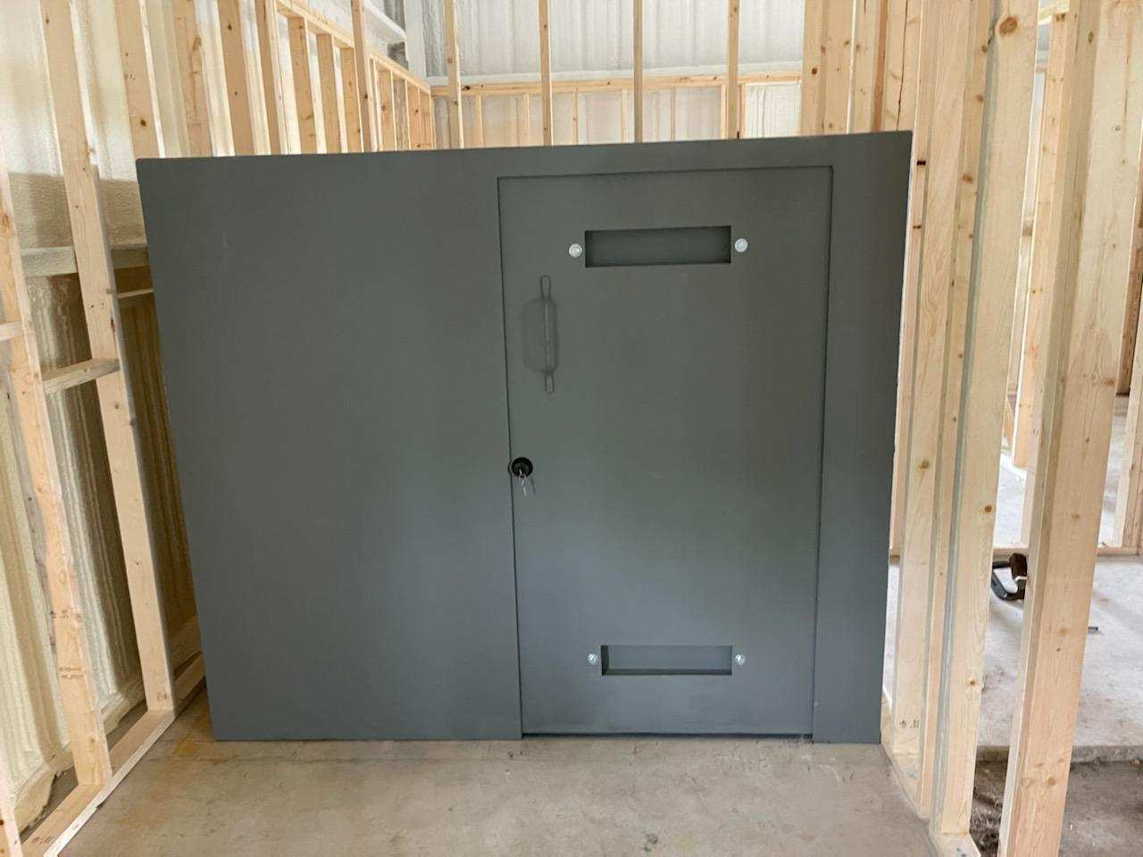 Above-ground storm safe room installed in a backyard with reinforced steel walls