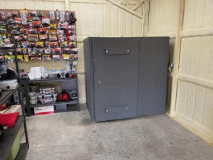 Interior view of an in-garage storm safe room with a steel door.