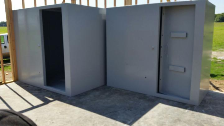 Steel safe rooms positioned on a concrete slab during installation