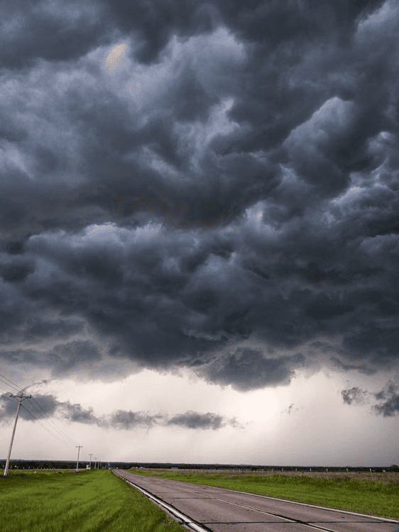 Dark storm clouds gathering over an Oklahoma roadway before severe weather.