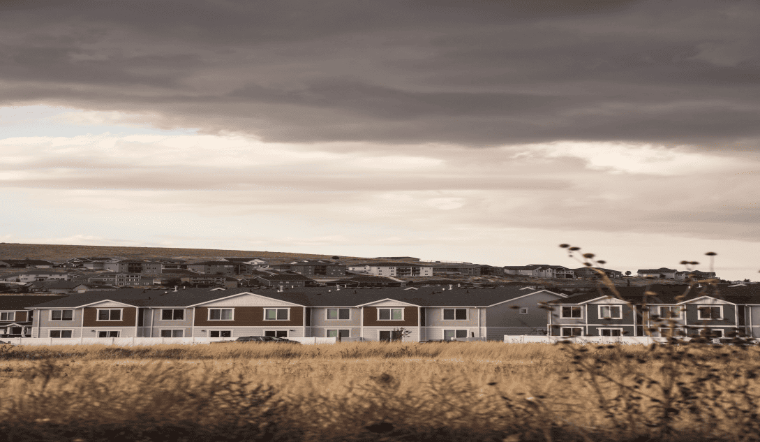 Residential neighborhood beneath dark storm clouds before severe summer weather.