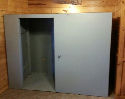 Open interior of an above-ground steel safe room with space for multiple occupants during severe weather.